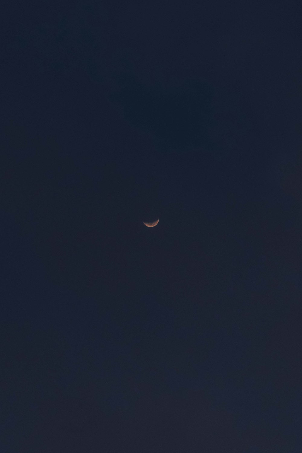 the moon is seen in the dark sky