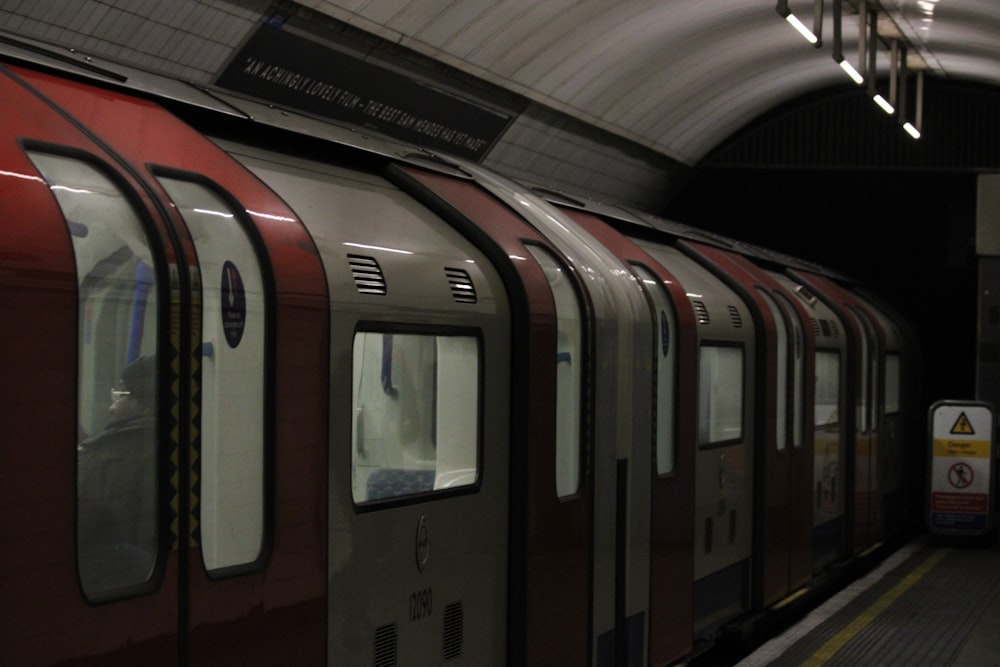 a red and silver train at a train station