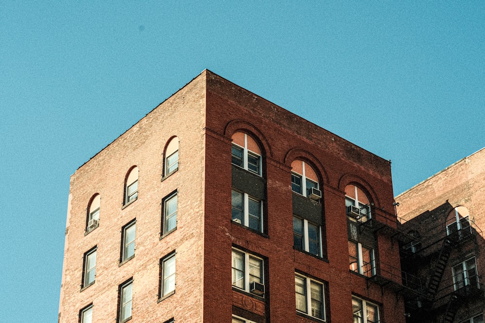 a tall brick building with a clock on the top of it