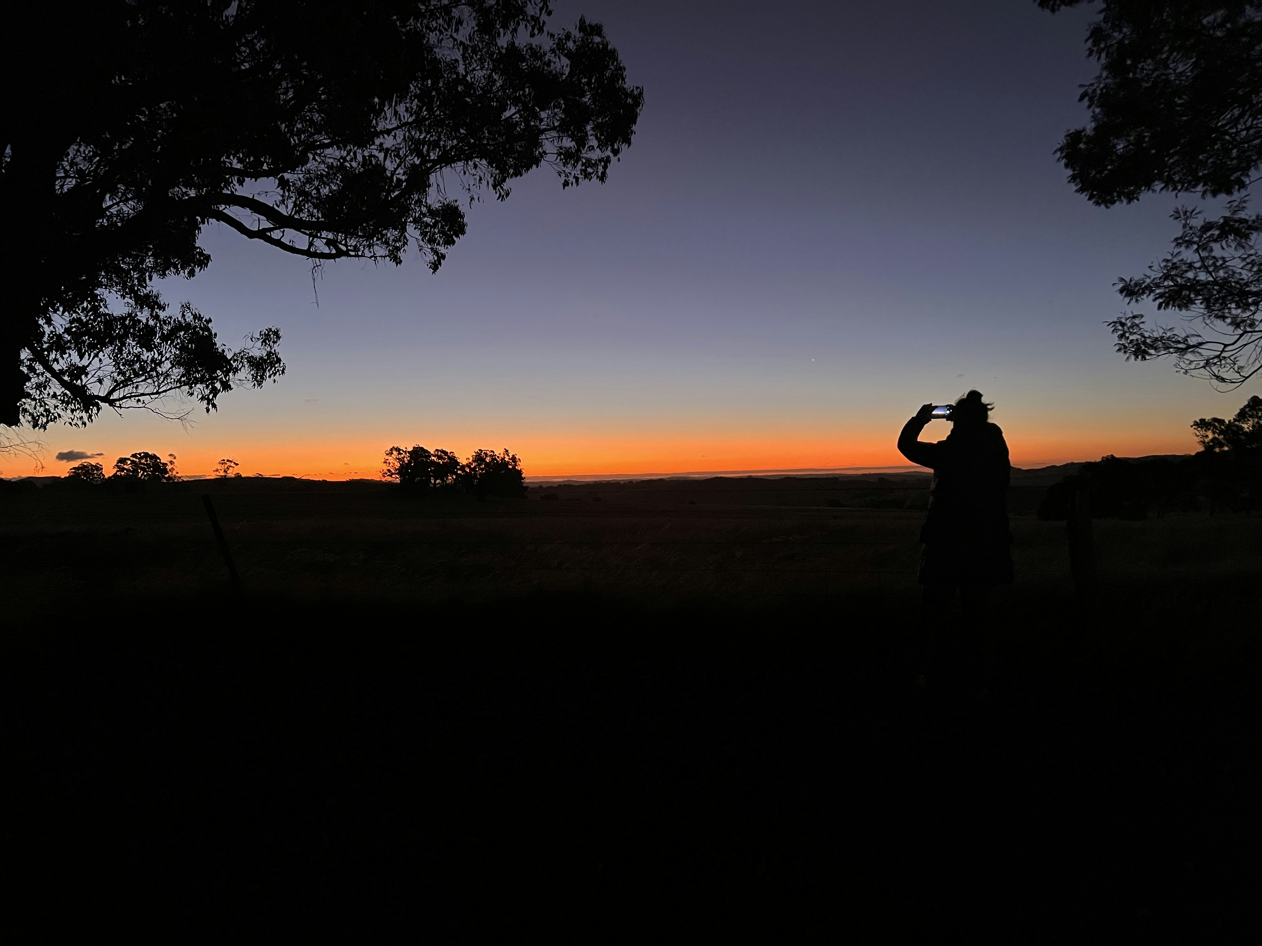 a man is taking a picture of the sunset