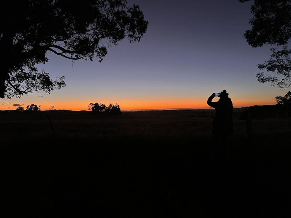 a man is taking a picture of the sunset