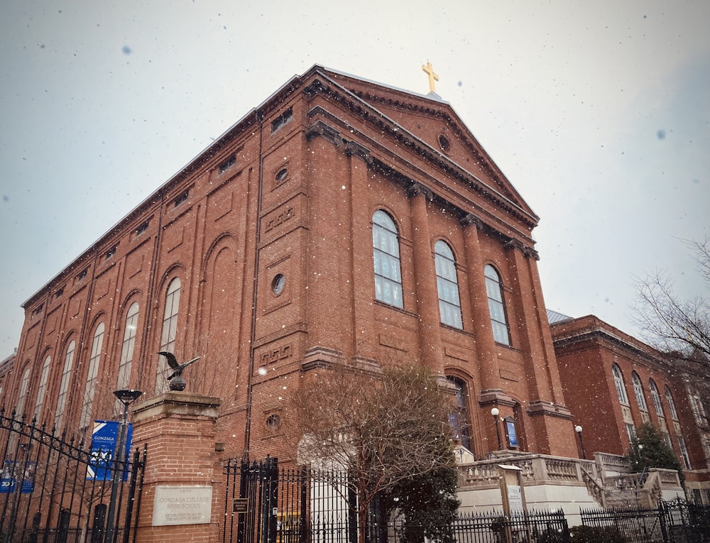 a large brick building with a cross on top of it