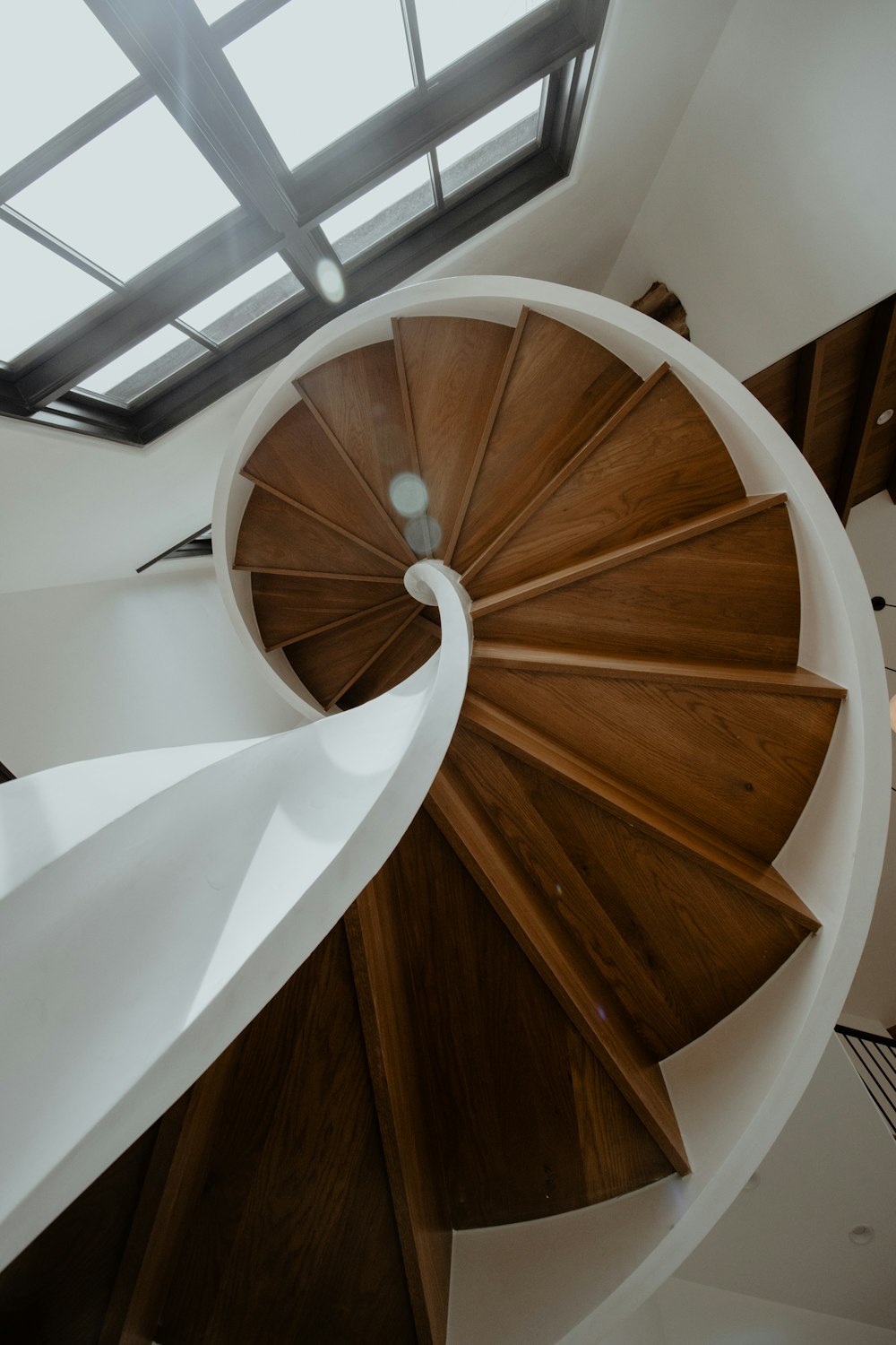 a spiral staircase in a house with a skylight