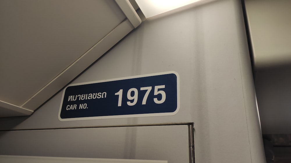 a blue and white street sign hanging from the side of a wall