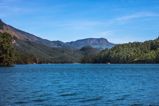 Scenic view of the serene Lake Maninjau surrounded by lush green hills and clear waters.