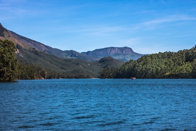 A serene landscape of Nainital's lake surrounded by hills.