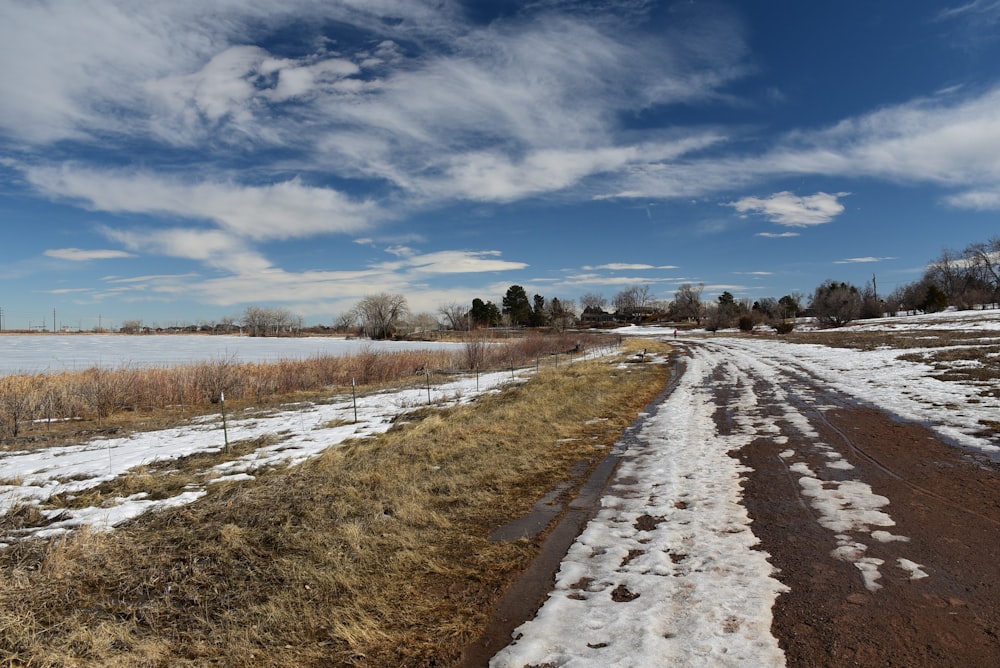 a dirt road that is next to a body of water