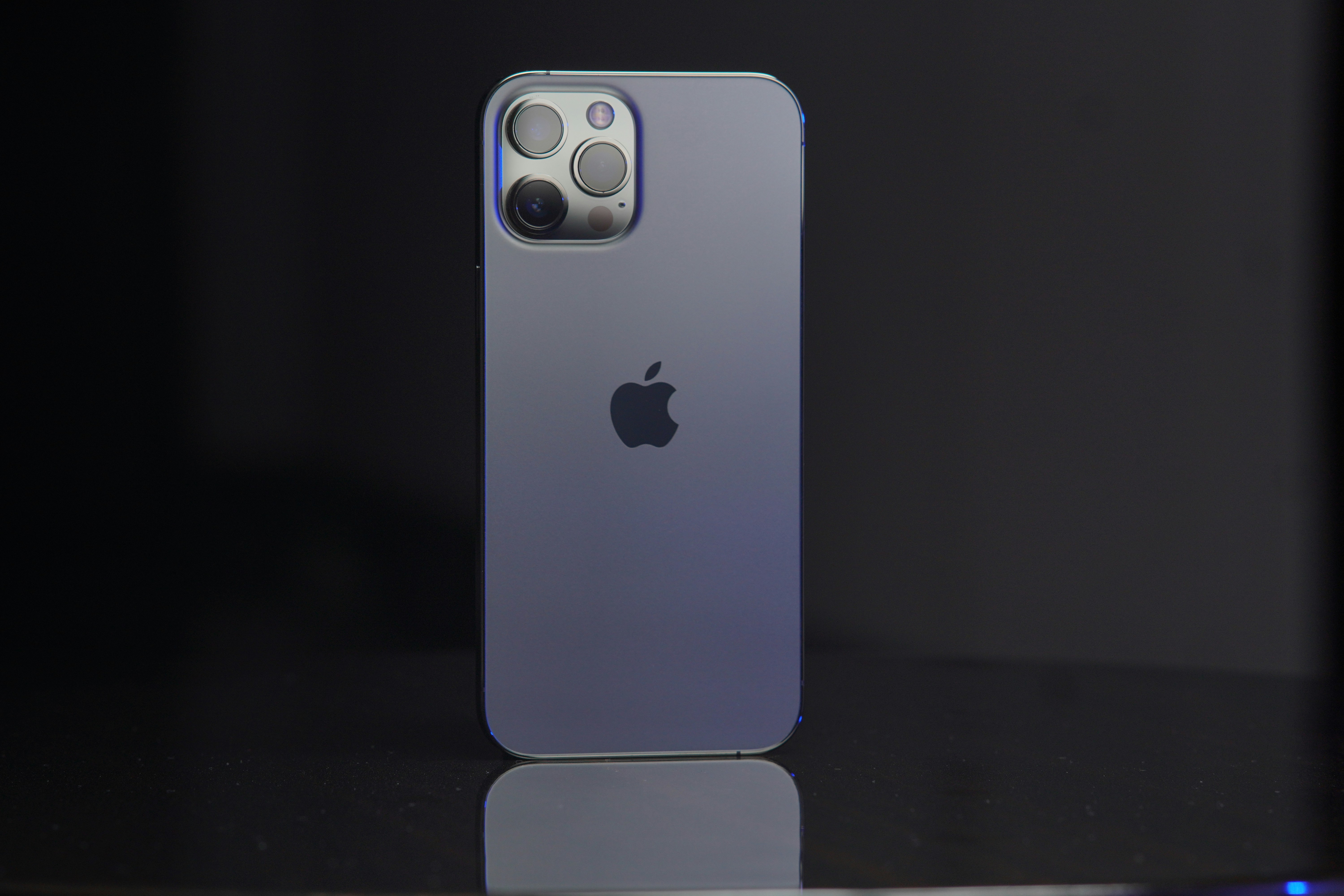 iPhone 14 Pro in deep purple color on dark background, professional product shot