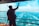 A man with a backpack waves at seagulls while standing on a boat with a vibrant blue ocean in the background. The sky is clear with light clouds, and the scene conveys a sense of freedom and exploration.