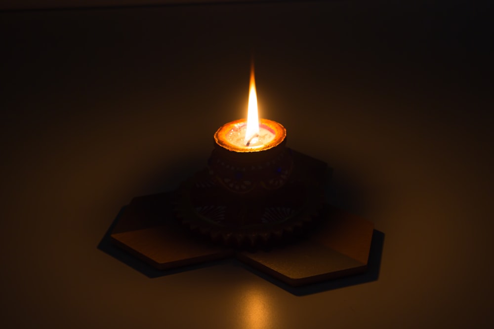 a lit candle sitting on top of a table