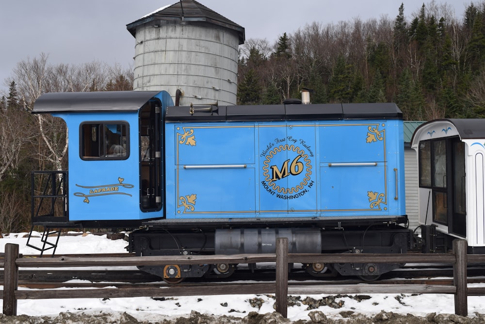 a blue train car sitting on the tracks