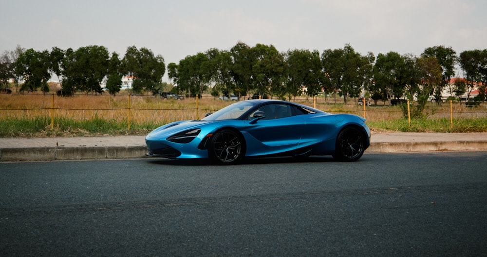 a blue sports car parked on the side of the road