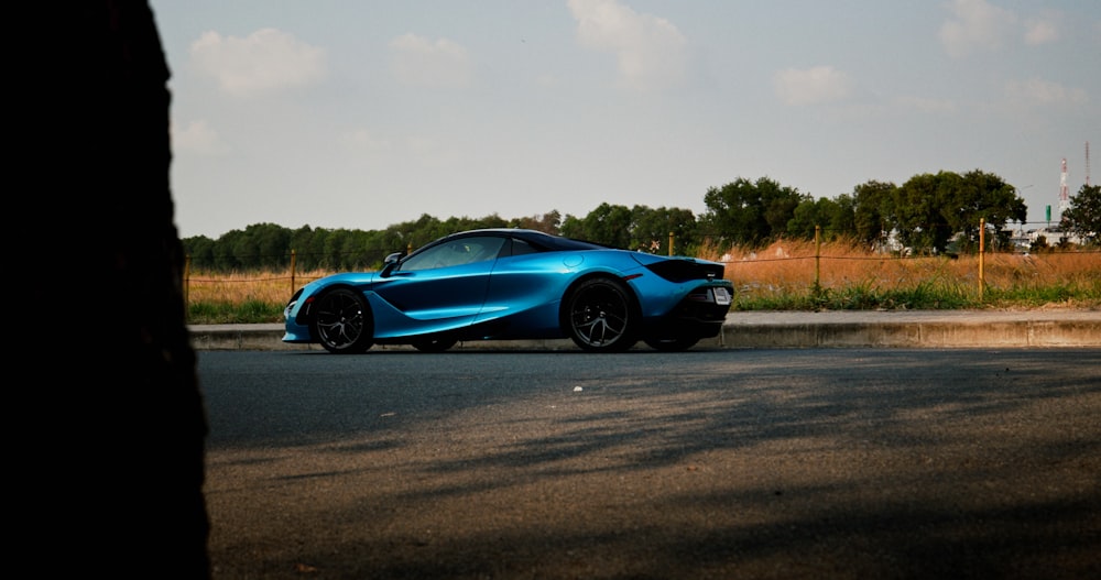 a blue sports car parked on the side of the road