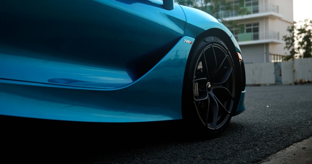 a blue sports car parked on the side of the road