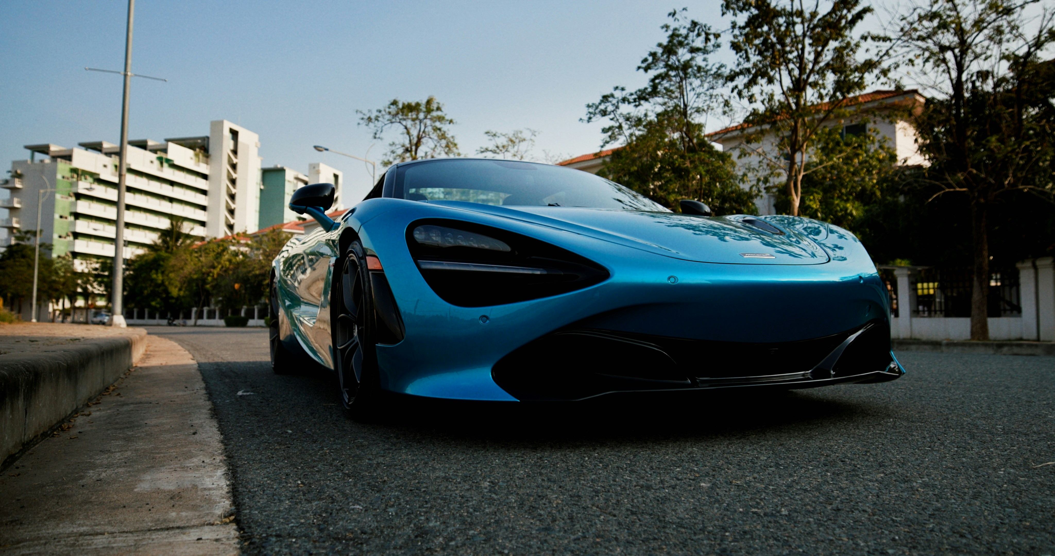 a blue sports car parked on the side of the road