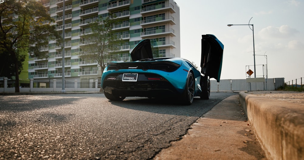 a blue sports car parked on the side of the road