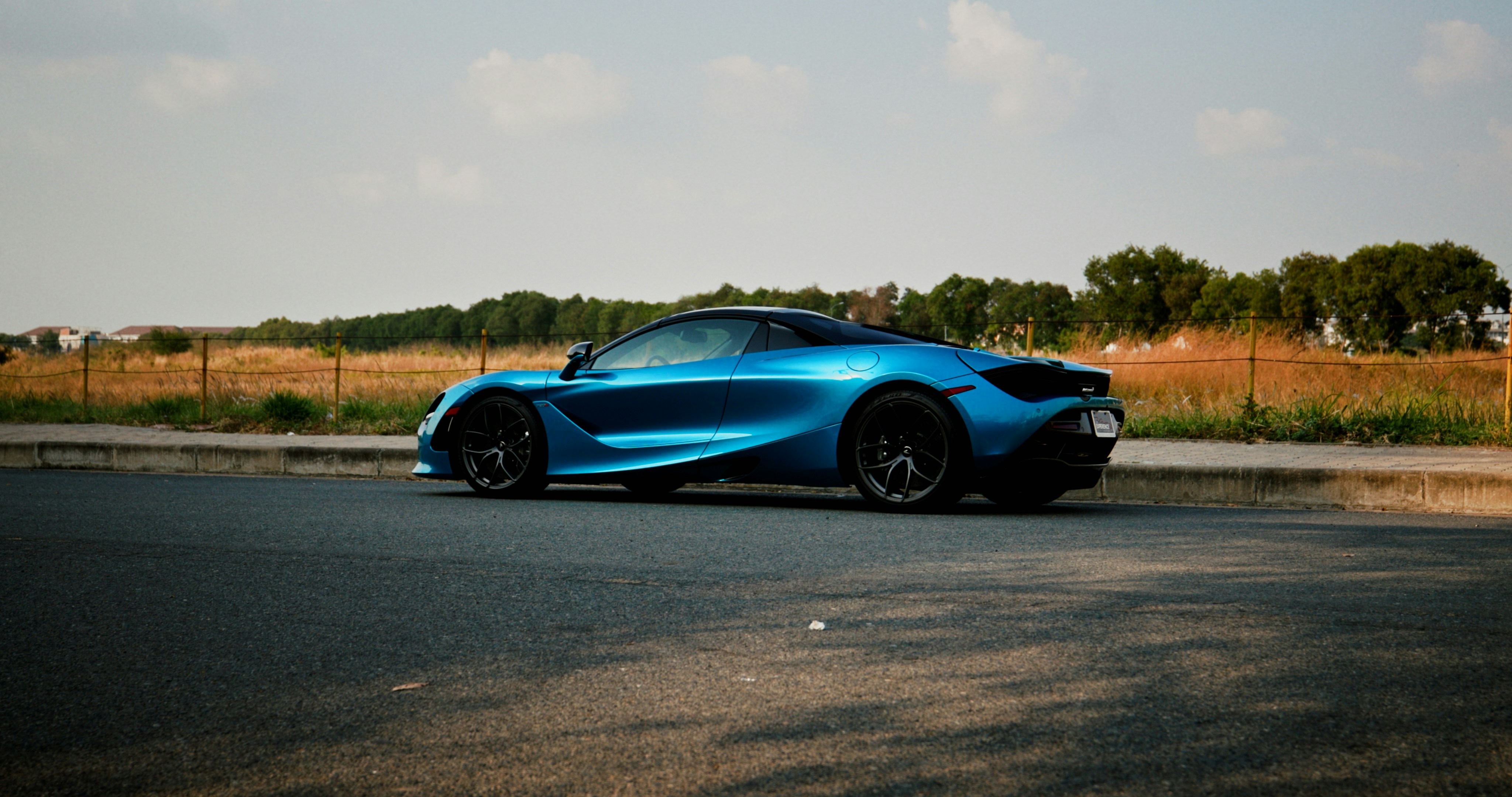 a blue sports car parked on the side of the road