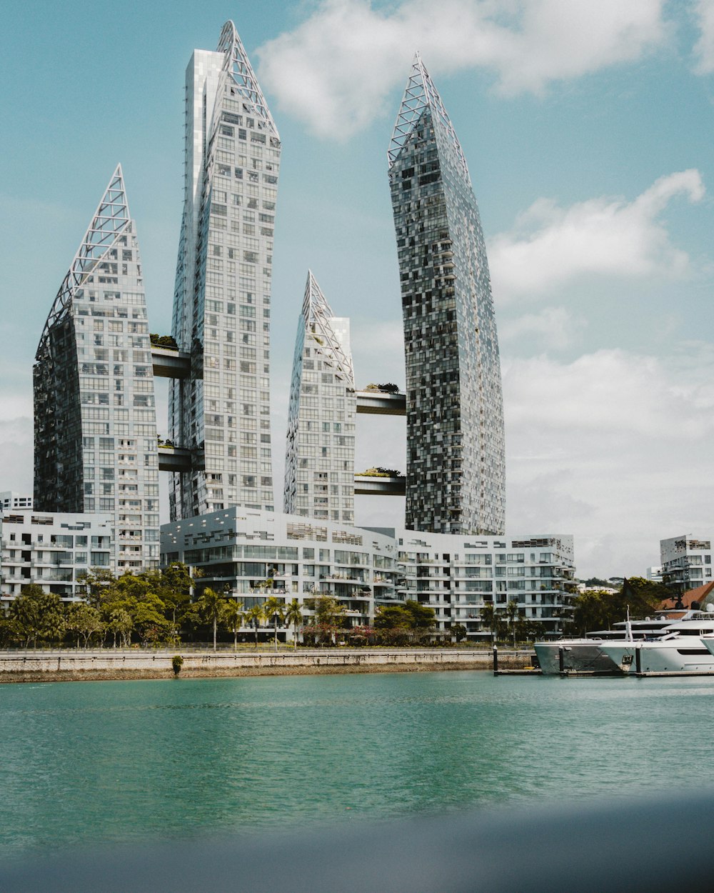 a group of tall buildings sitting next to a body of water