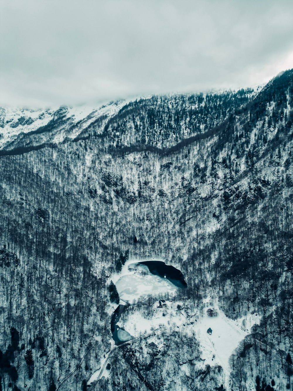 a snow covered mountain with a lake in the middle