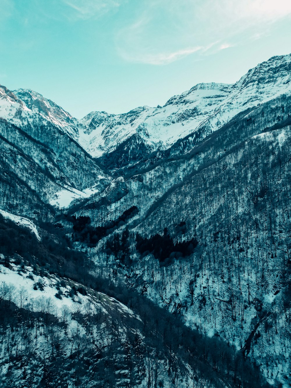 a mountain range covered in snow under a blue sky