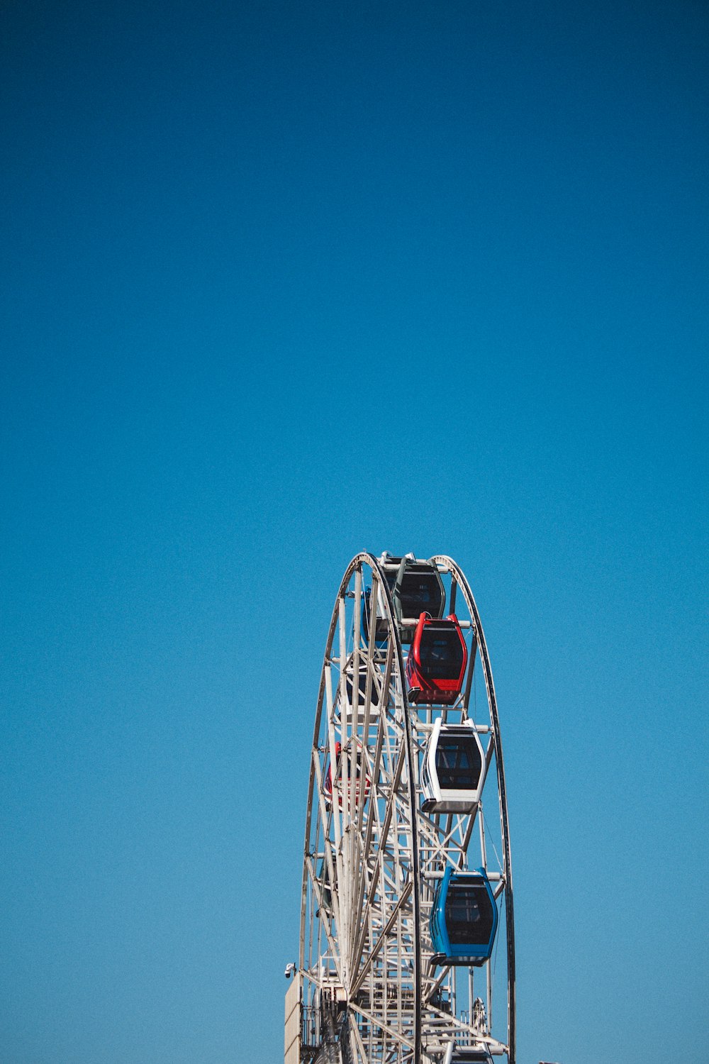 a ferris wheel on a beach with a blue sky in the background
