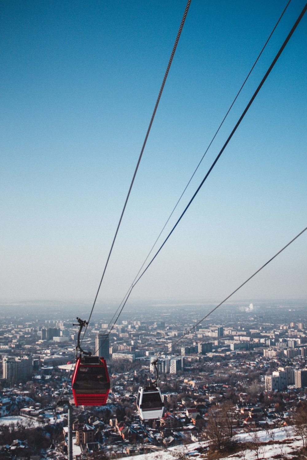 a ski lift with a view of a city in the background