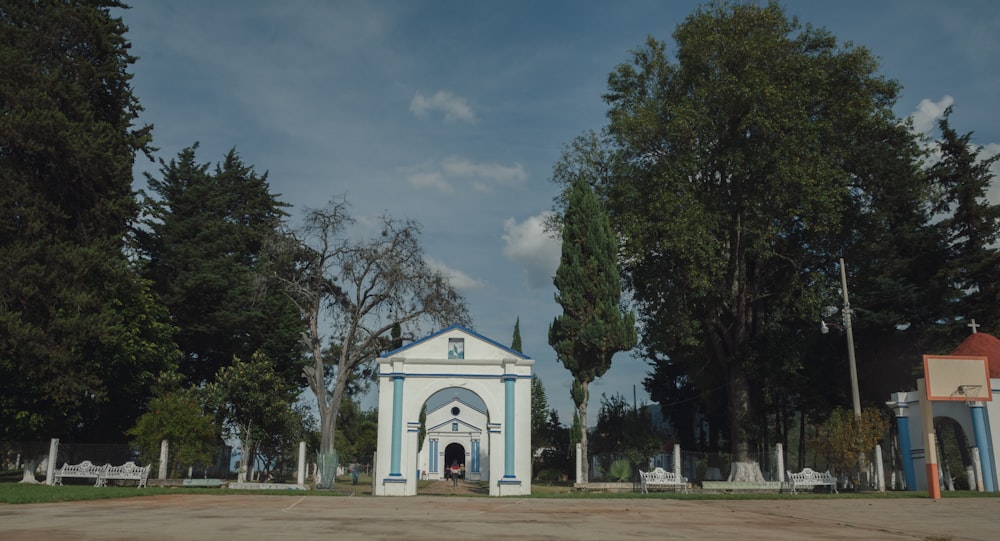 a blue and white church surrounded by trees