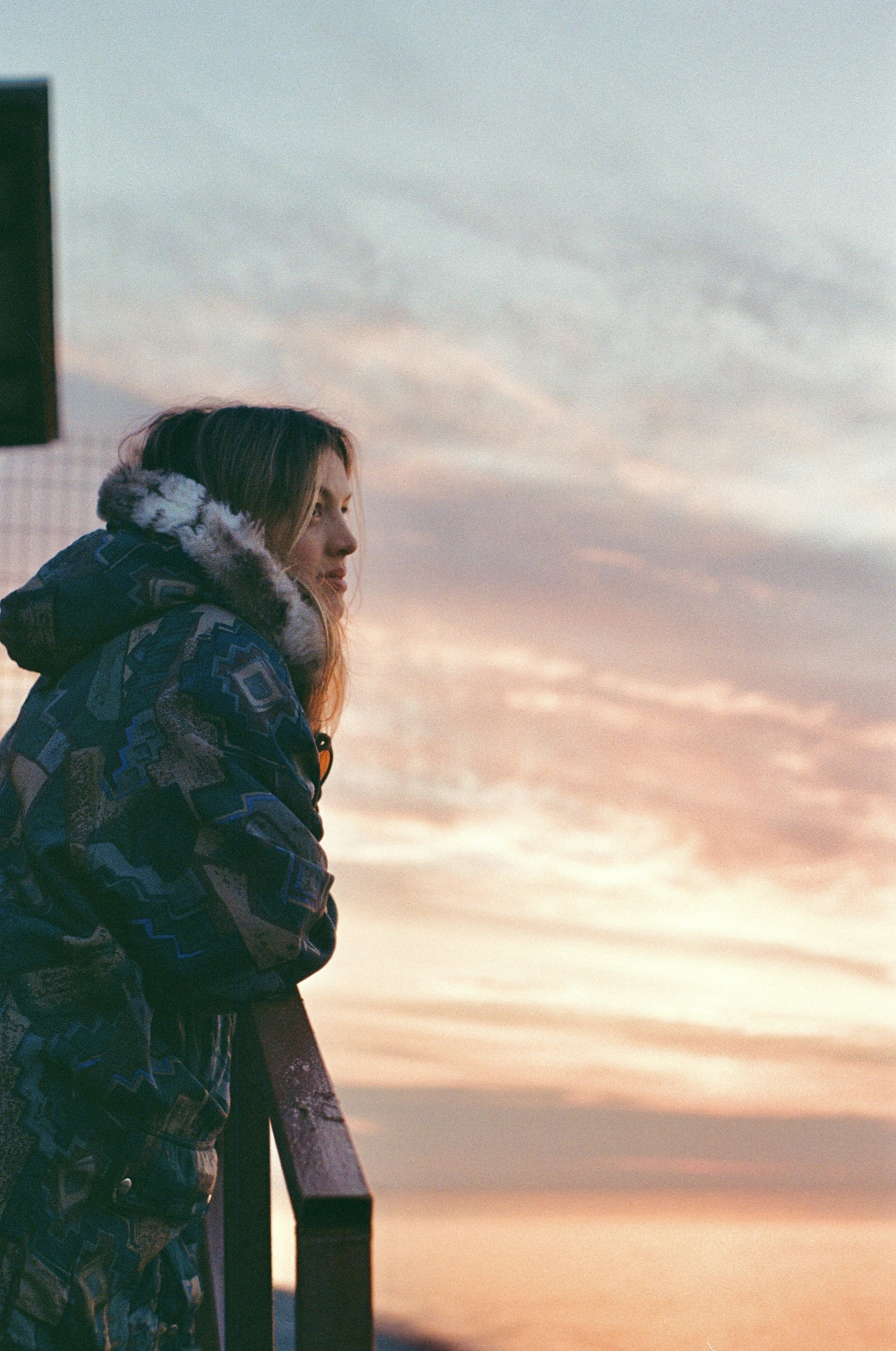 a woman standing on top of a balcony next to a traffic light
