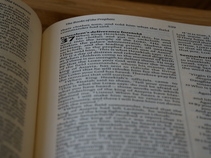 A close-up of an open Bible with highlighted verses, softly lit by a candle.
