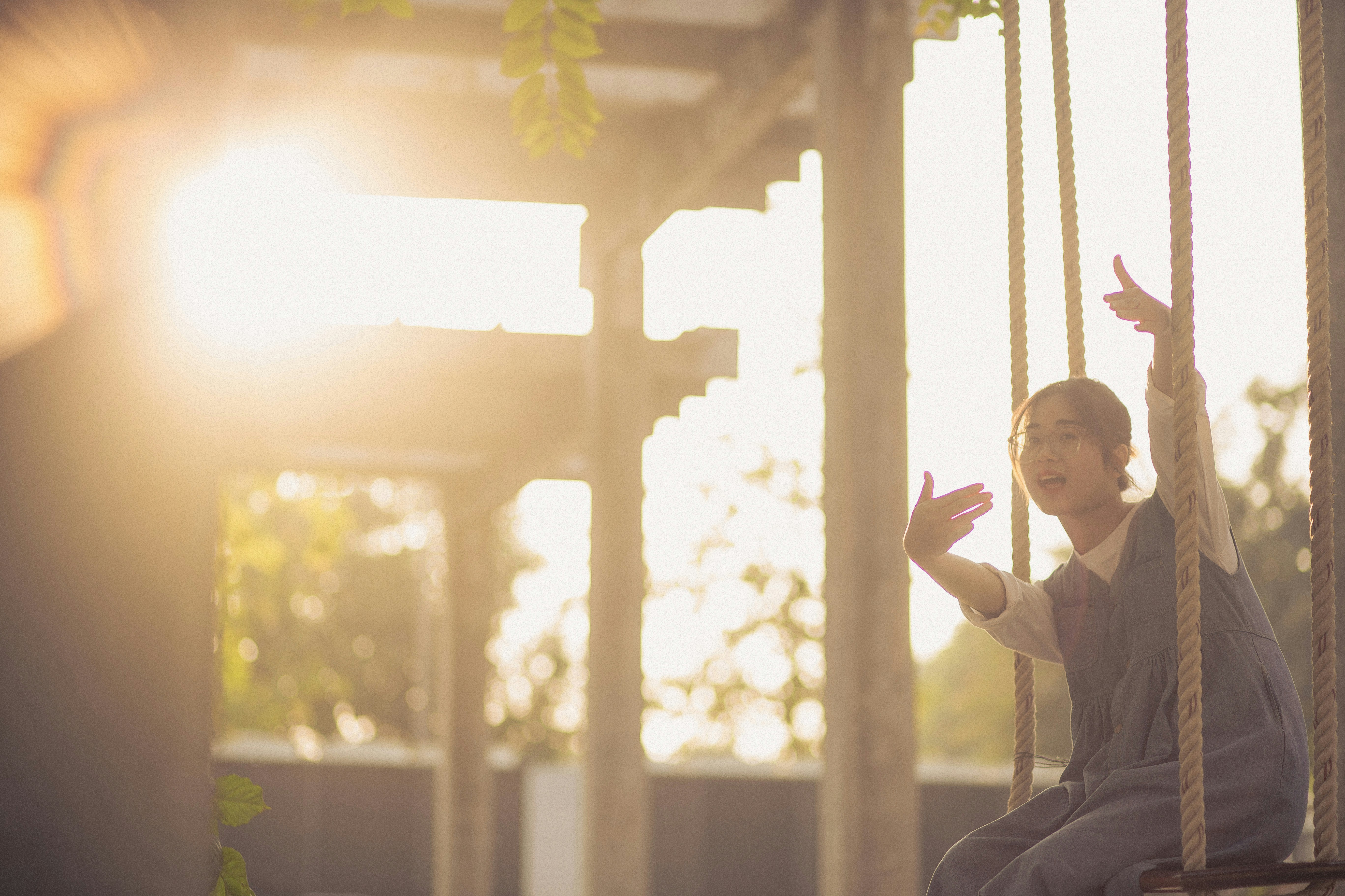 a young boy sitting on a swing in a park