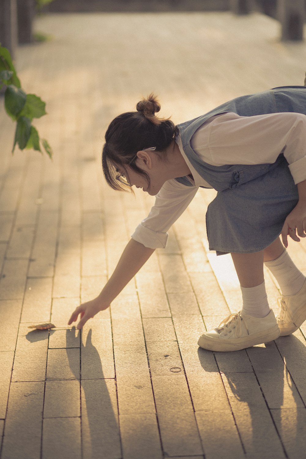 a woman bending over to pick up a piece of wood