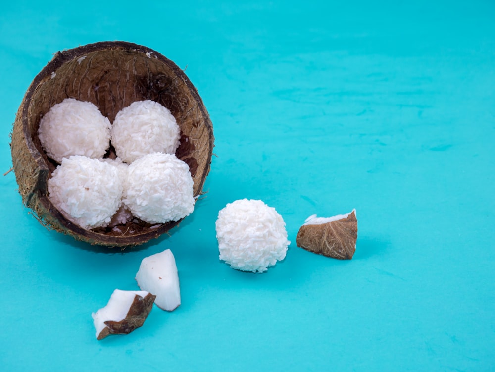 una cáscara de coco con trozos de coco sobre un fondo azul