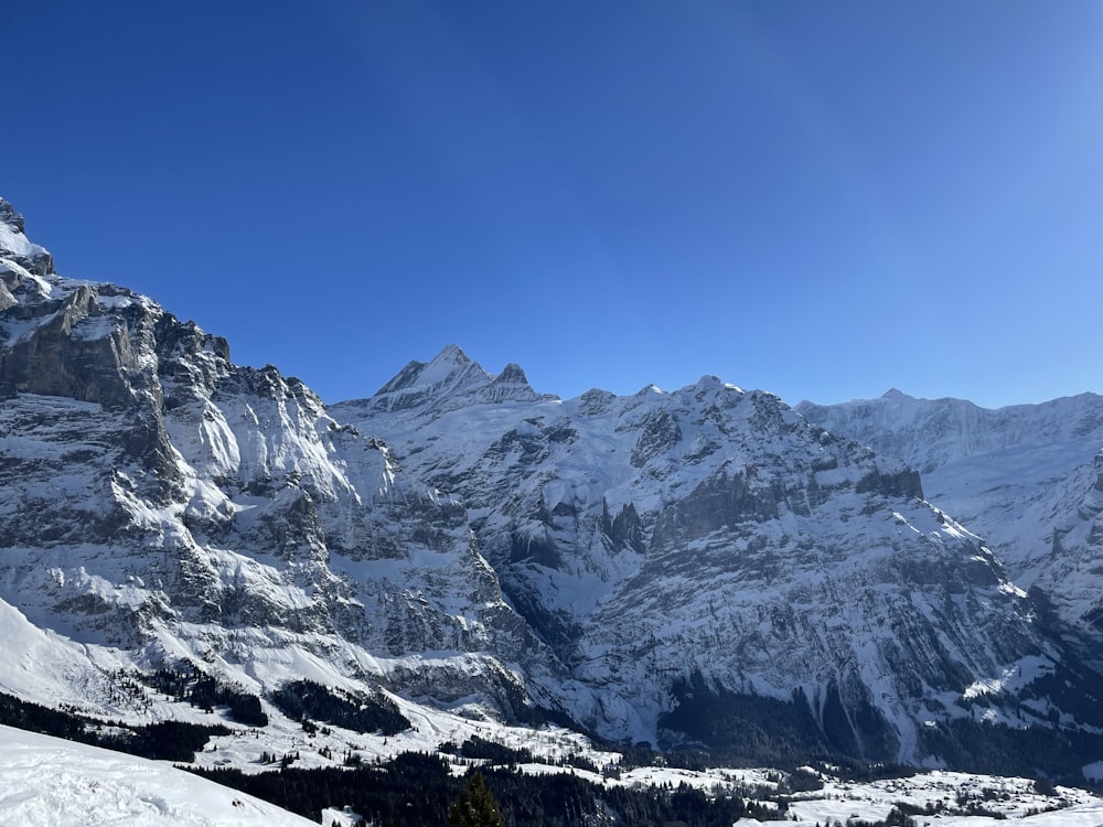 Une montagne enneigée avec un ciel bleu en arrière-plan