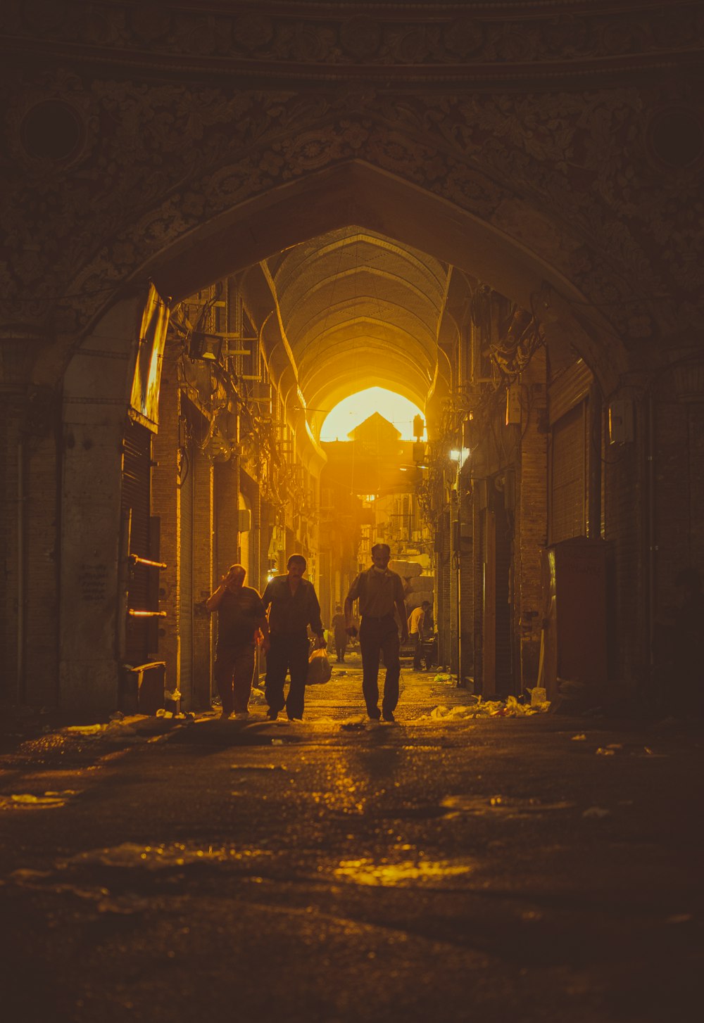 a group of people walking down a street at night