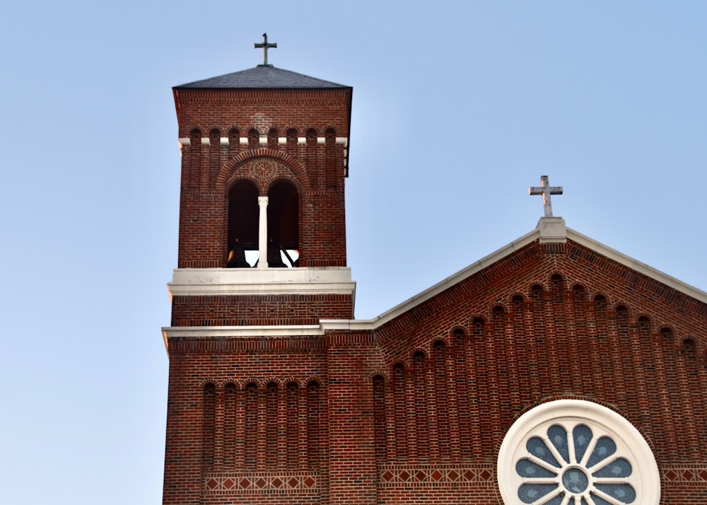 a church with a clock tower and a cross on top