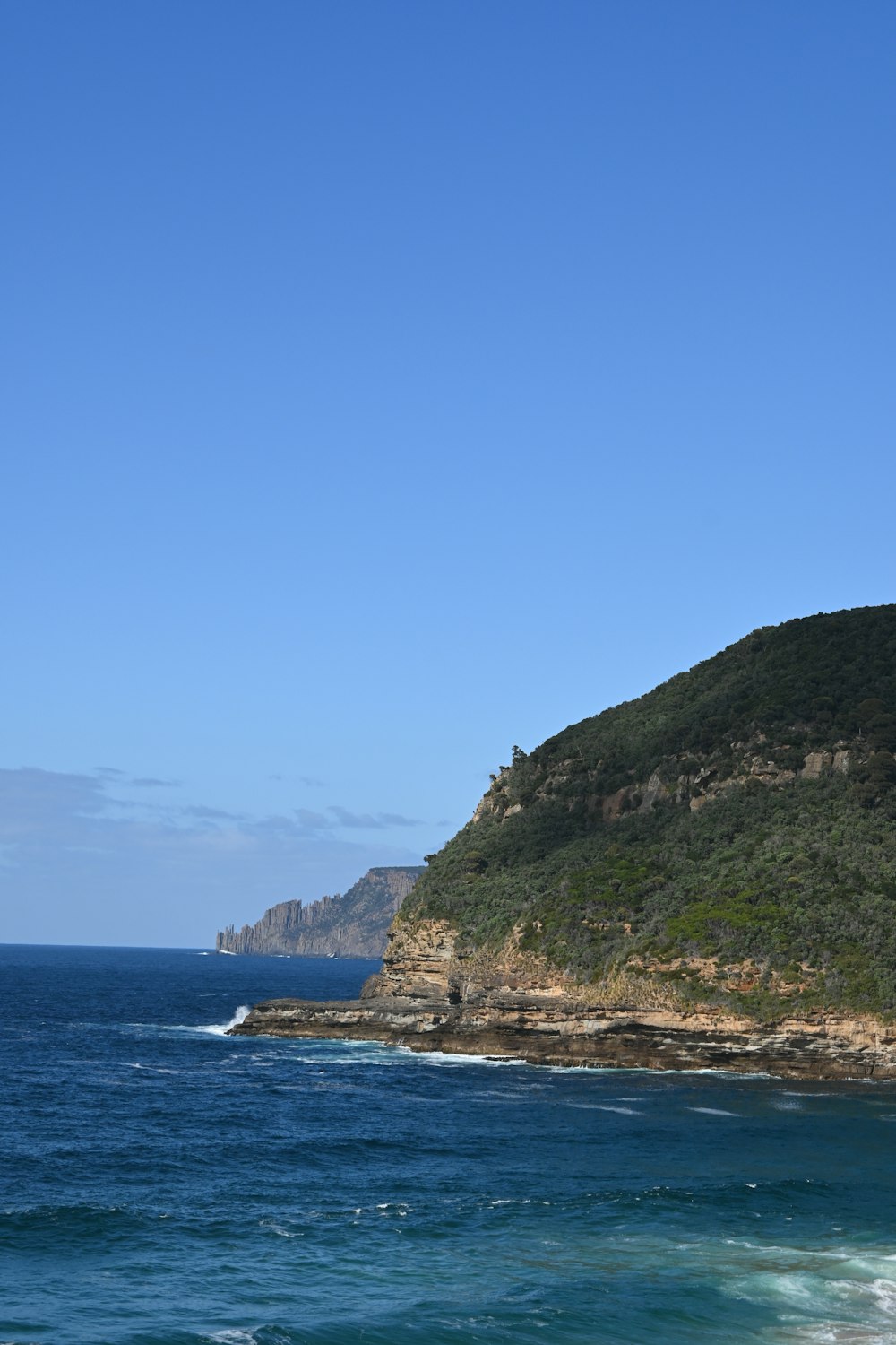 a view of the ocean with a hill in the background