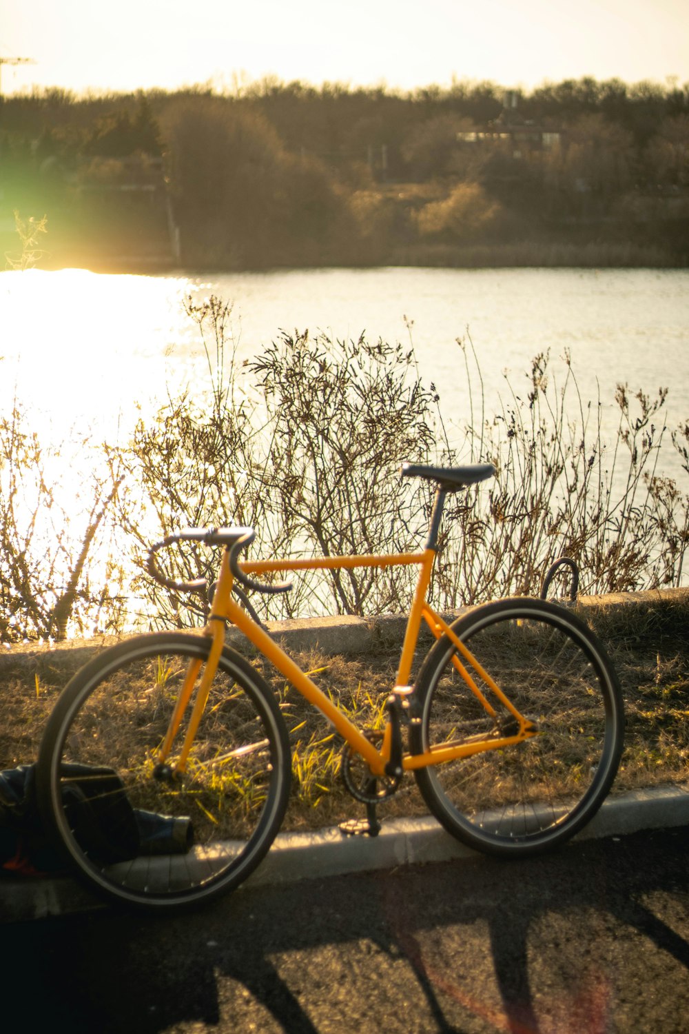 a yellow bike parked next to a body of water
