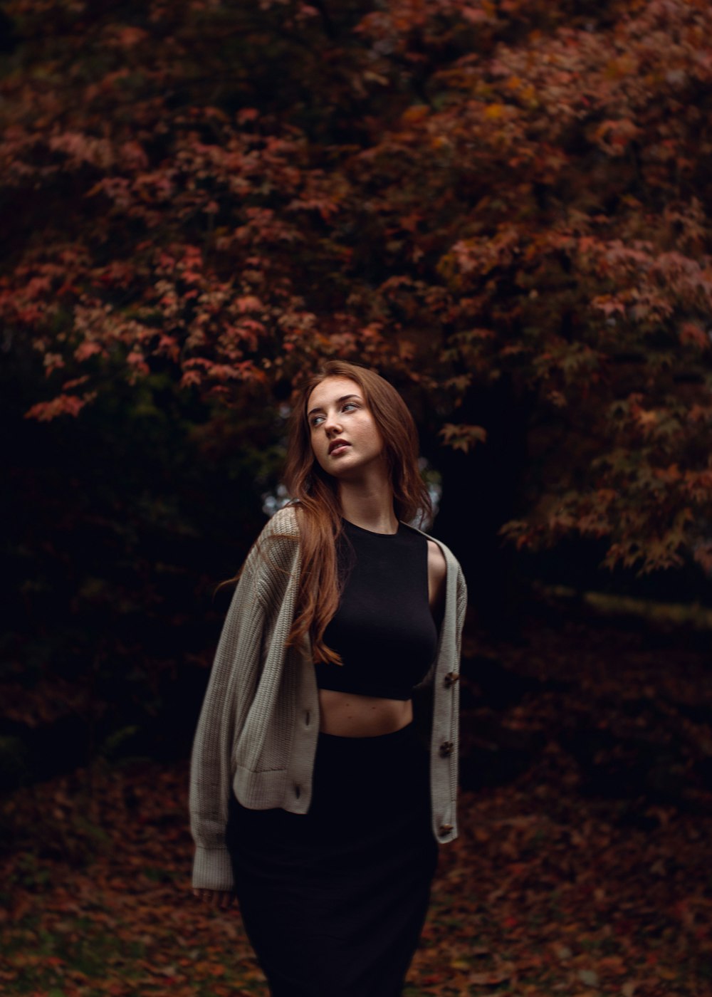 a woman standing in front of a tree