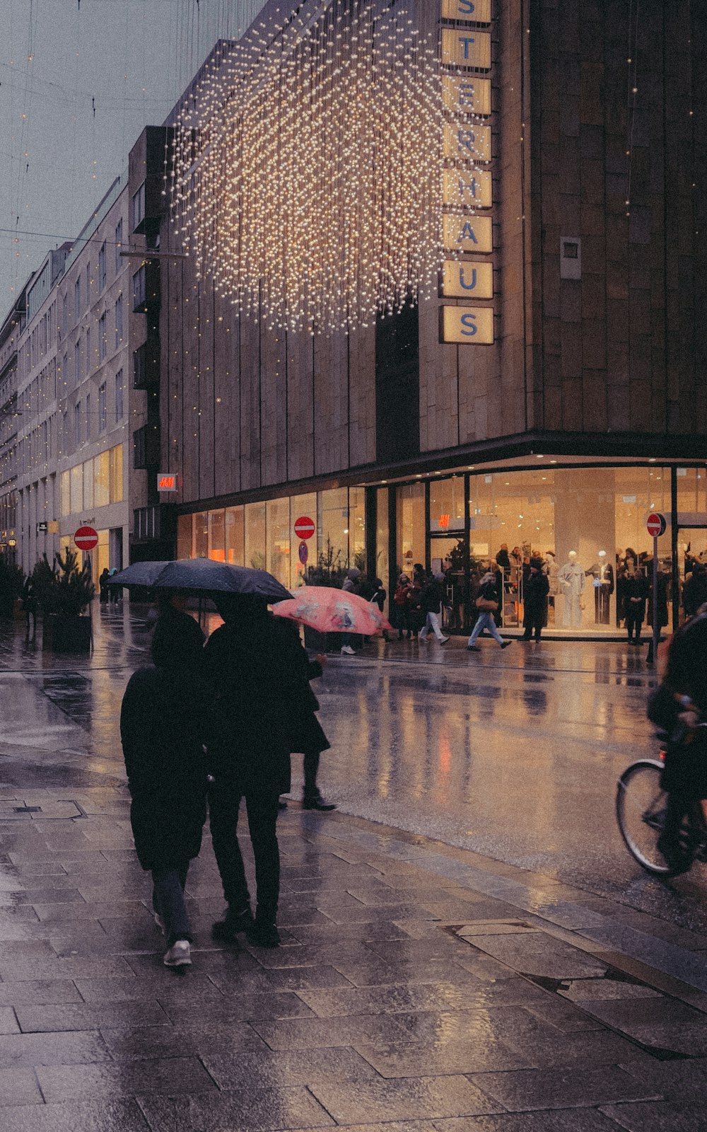 Eine Gruppe von Menschen, die mit Regenschirmen eine Straße entlang gehen