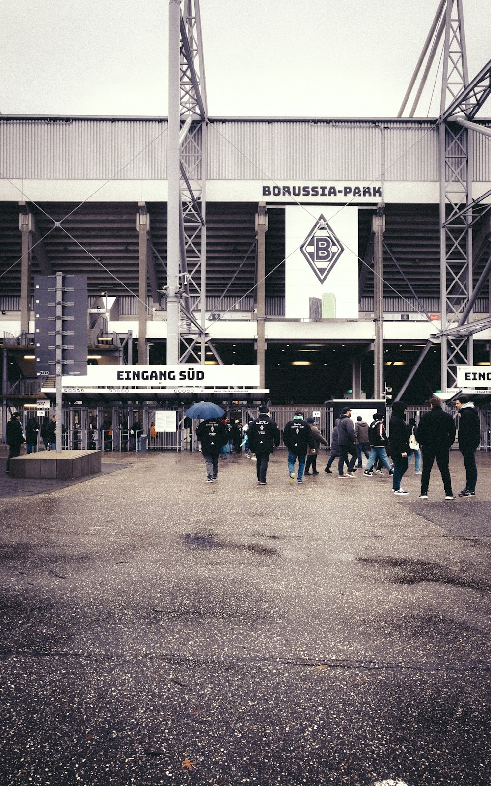 a group of people standing in front of a stadium