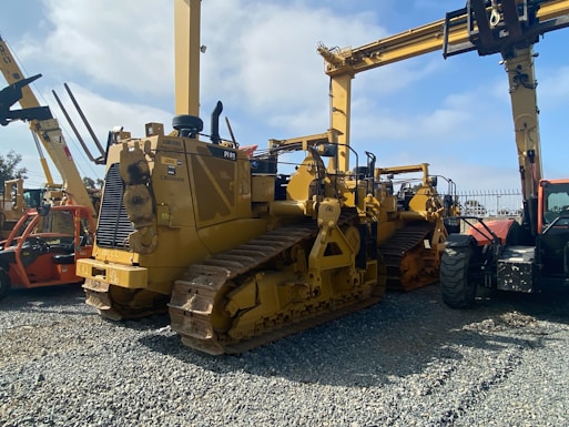Heavy construction machinery lined up in a yard ready for sale.