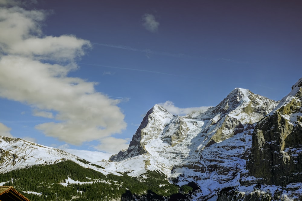 a snow covered mountain with a cabin in the foreground