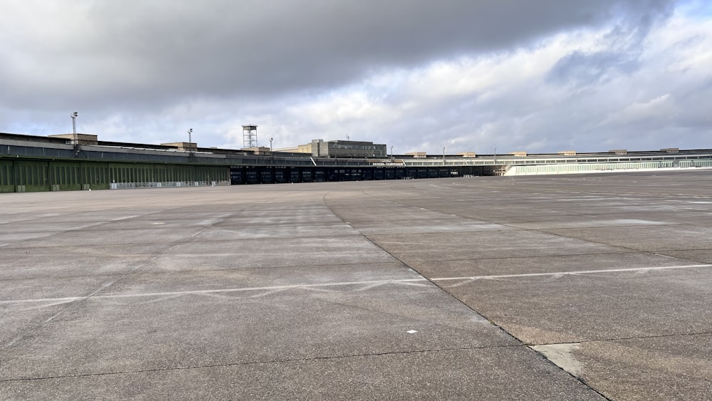 an empty parking lot with a building in the background