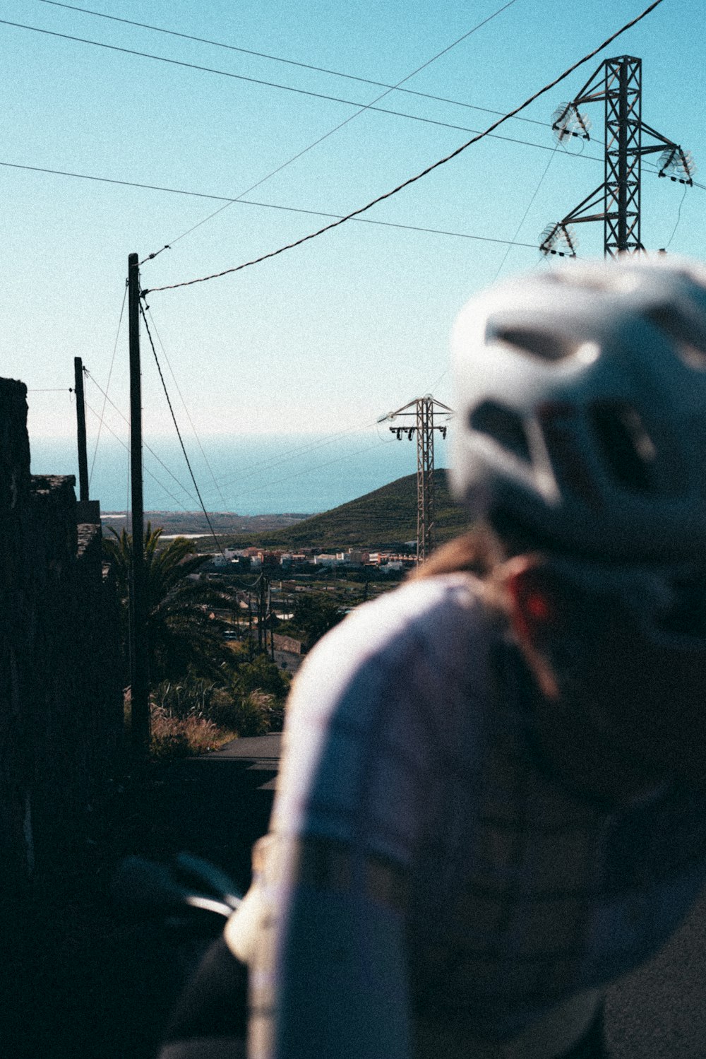 a man riding a bike down a street next to power lines