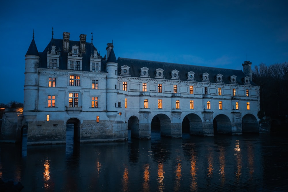 a large building sitting on top of a river next to a bridge