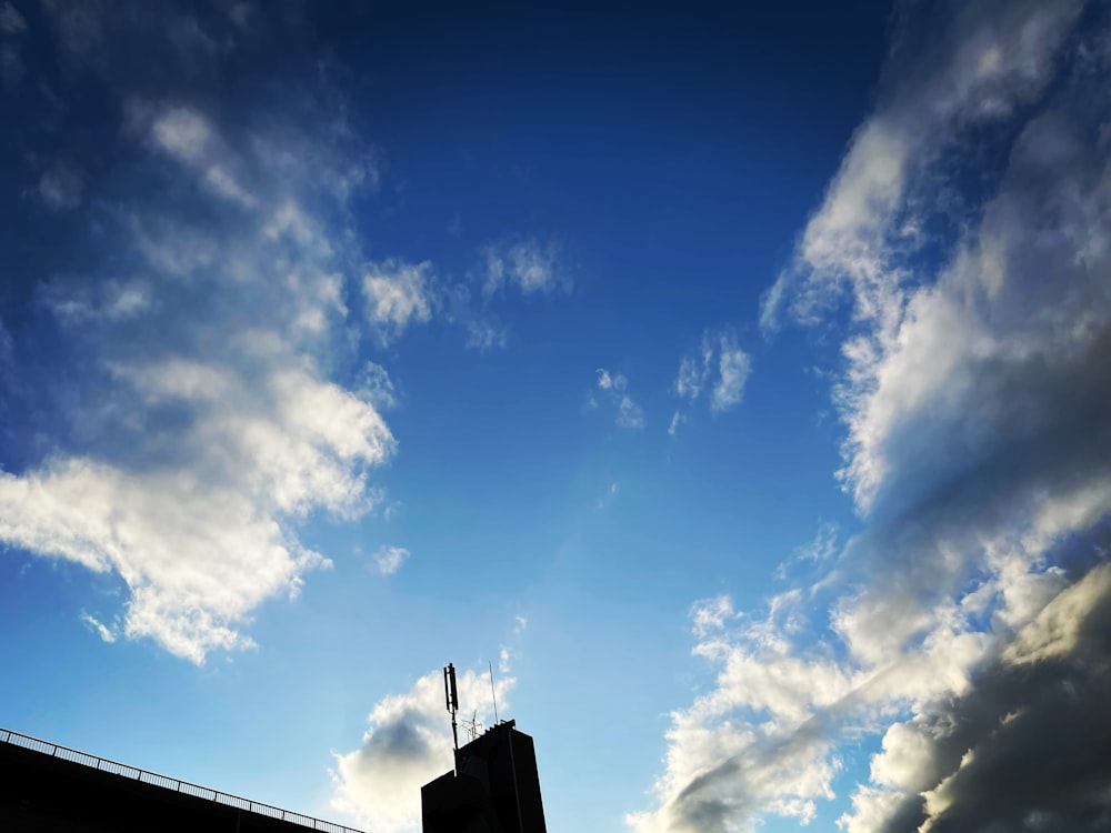 a very tall building sitting under a cloudy blue sky