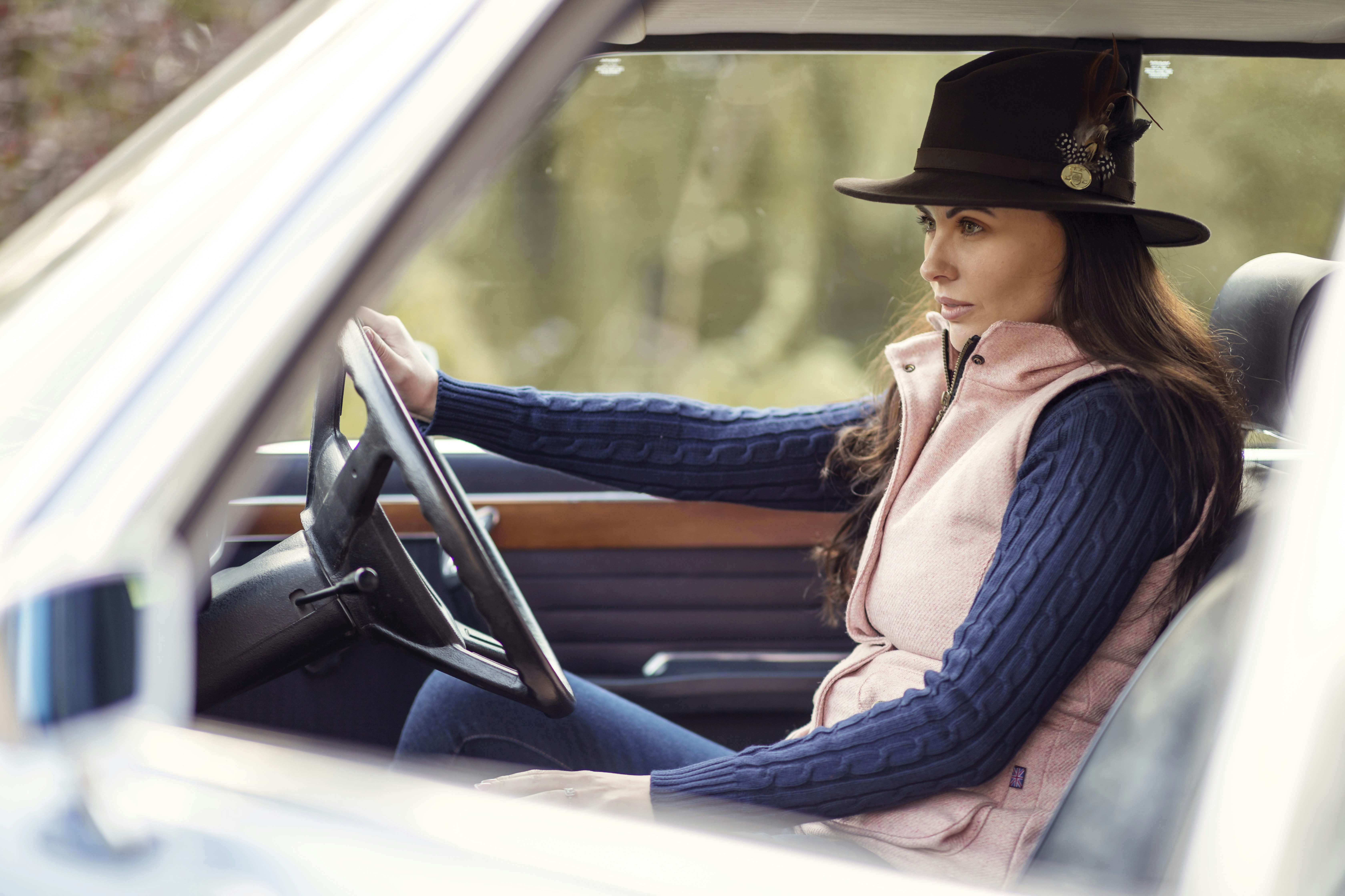 Una donna che indossa un cappello seduta in una macchina