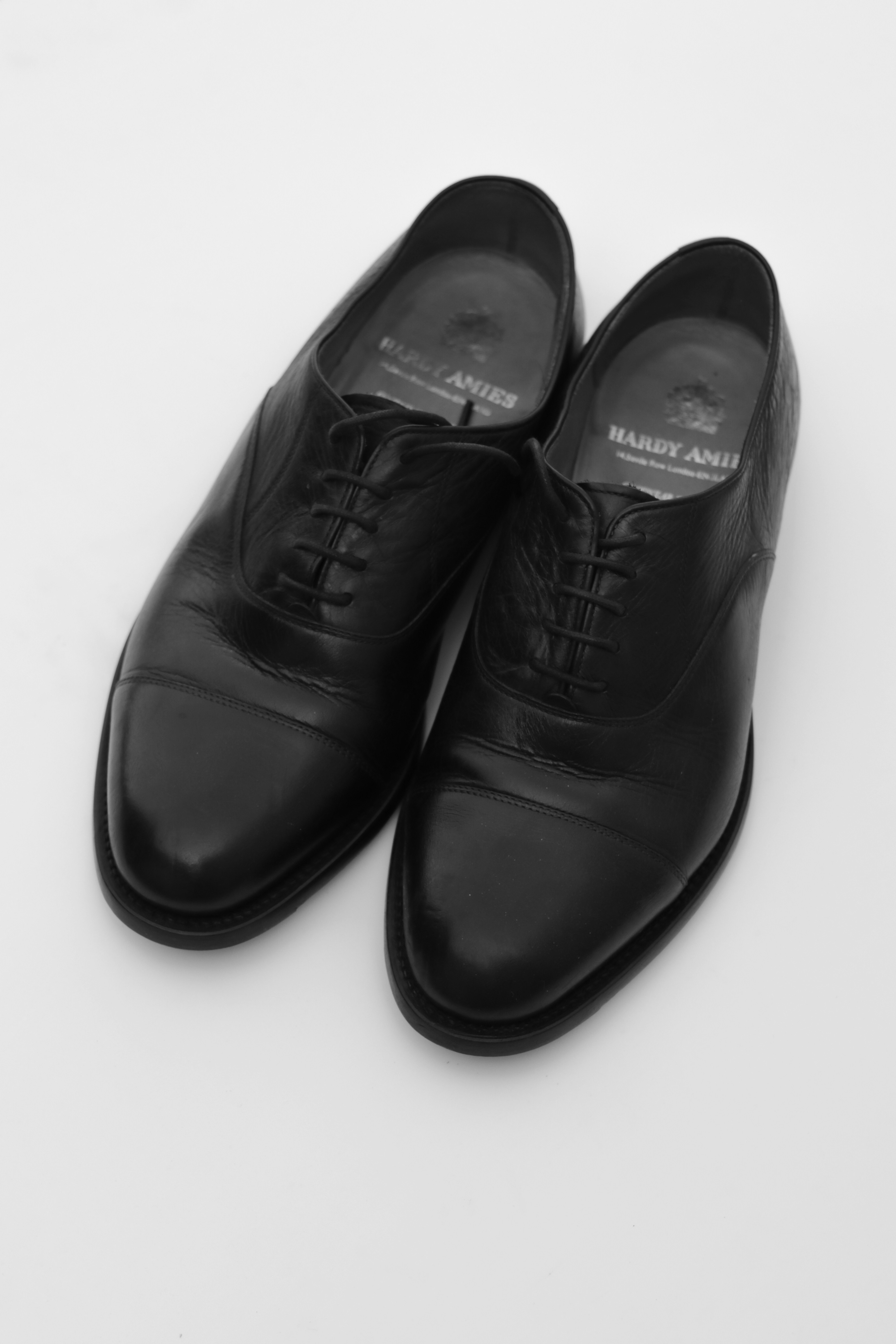 Clean leather shoes on a bright white background with warm side lighting
