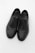 Close-up of elegant black leather men's dress shoes on a minimalist white background.