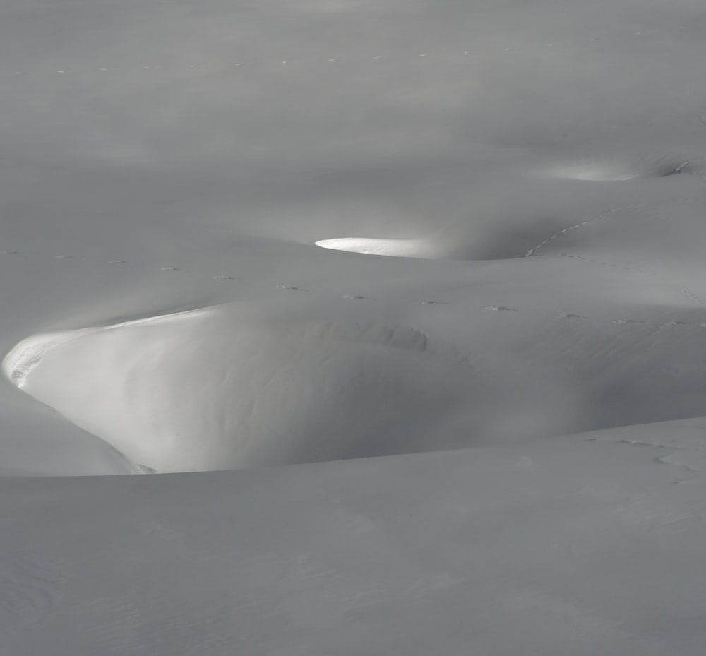 a snow covered hill with a few clouds in the sky